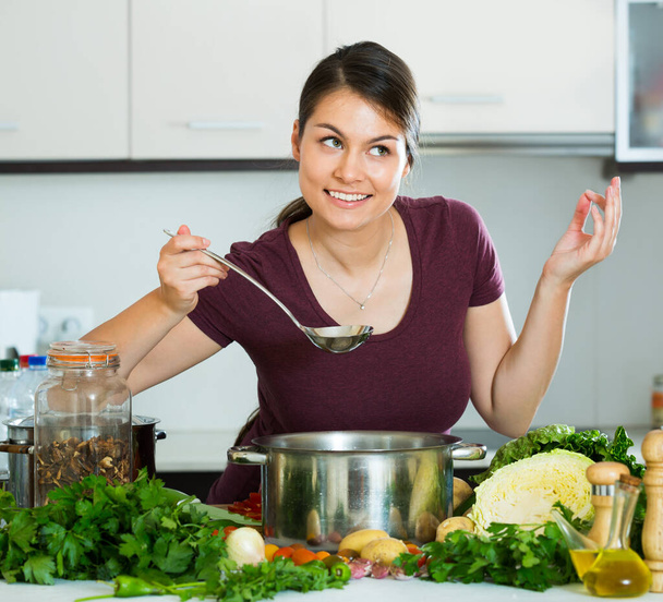 Young brunette cooking vegetables - Фото, зображення