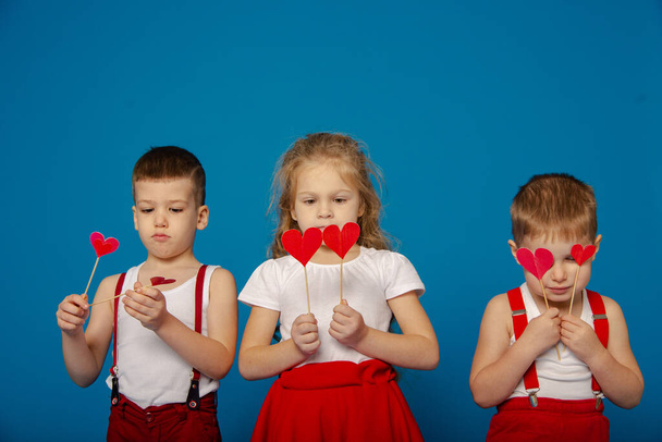 Three cute baby on a blue background on Valentine's Day - Foto, Imagen