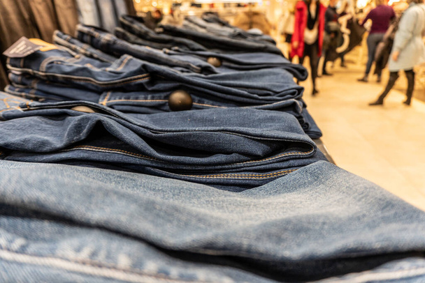 Стек джинсових штанів в торговому центрі лежить рядами
 - Фото, зображення