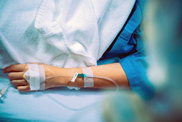 Atención médica, imagen cercana del goteo intravenoso en la mano del paciente en el hospital
. - Foto, imagen