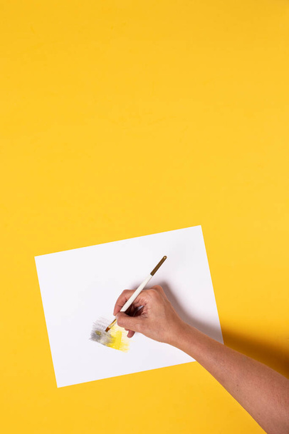 Käsi harjalla maalaus harmaa ja keltainen kaltevuus akvarellikyniä keltainen pöytä - Valokuva, kuva