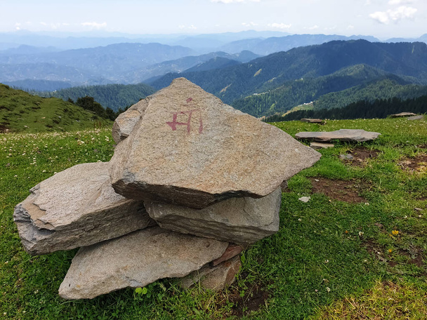 Maa-Wort auf Stein geschrieben mit schönen grünen Bergen im Hintergrund - Foto, Bild