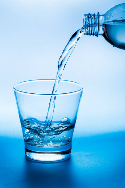 Water dat in glas wordt gegoten - Foto, afbeelding