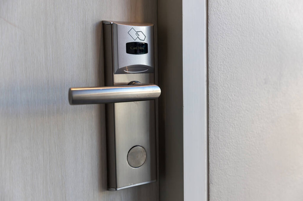 Smart card door key lock system in hotel. Hotel electronic lock on wooden door. Entrance door with electronic card lock security. Digital door lock security systems for access protection of hotel - Foto, afbeelding