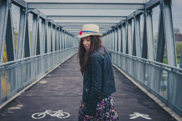 Pretty girl walking away on a bridge - Фото, зображення