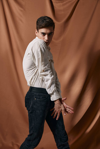 man in white shirt self confidence posing fabric brown background - Foto, Bild