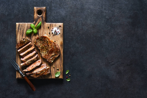 Grilled beef steak with herbs and spices. Top view with space to copy text - Фото, зображення