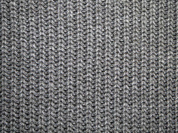 Texture of wool knitted fabric from yarn, closeup. Image for the background, wallpaper. wool carpet or sweater. Gray texture. Modern design. - Photo, Image