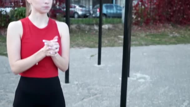 camera gaat neer en omhoog langs lichaam van rondborstige dame in sportkleding op sportveld - Video