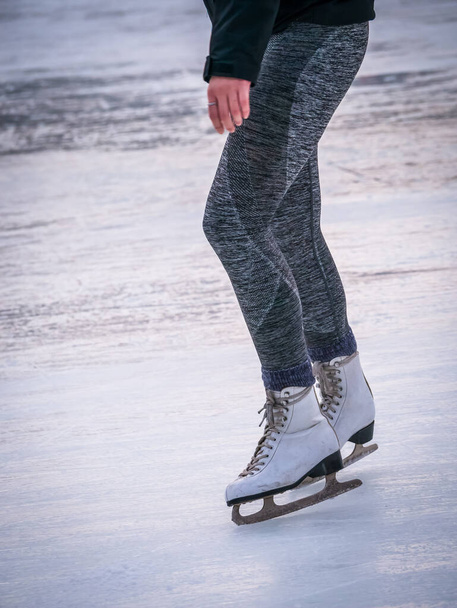 Ноги женщины с коньками на льду. Конькобежный спорт. - Фото, изображение