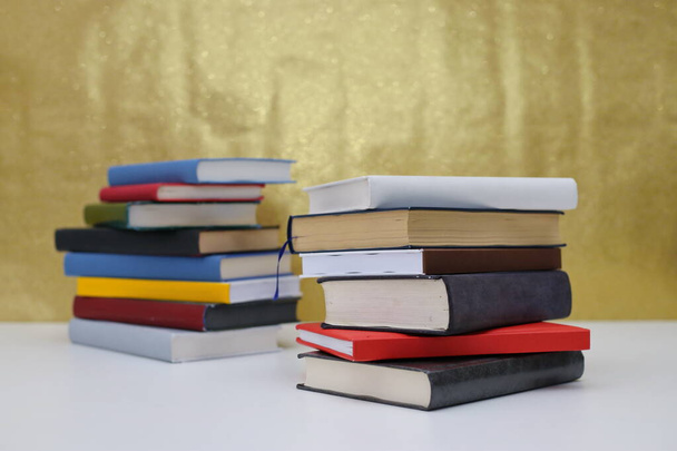 Книги на столе с золотым фоном - Фото, изображение