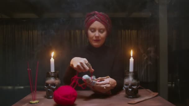 Sénior bruja adivina utiliza muñeca vudú y cuerda roja a terrible ritual mágico - Metraje, vídeo