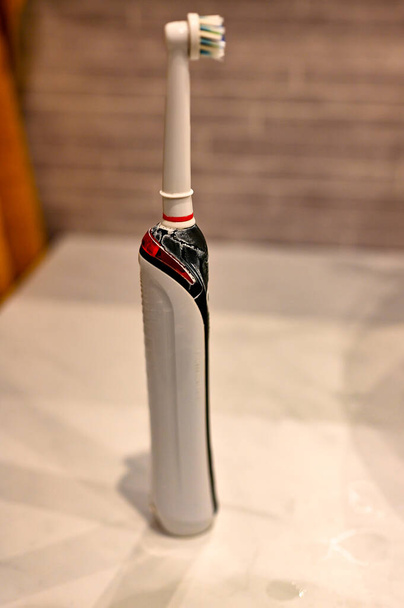 sucio cepillo de dientes eléctrico usado de pie en el baño - Foto, Imagen