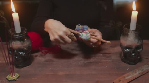 Nahaufnahme einer Wahrsagerin mit Voodoo-Puppe und rotem Seil zu schrecklichem magischen Ritual - Filmmaterial, Video