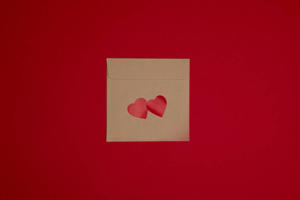 Valentine day composition. Confetti, envelope postcard with hearts on red background - Φωτογραφία, εικόνα