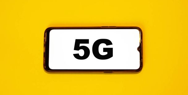 Okostelefon új 5G csatlakozással. Narancssárga szín 2021 - Fotó, kép