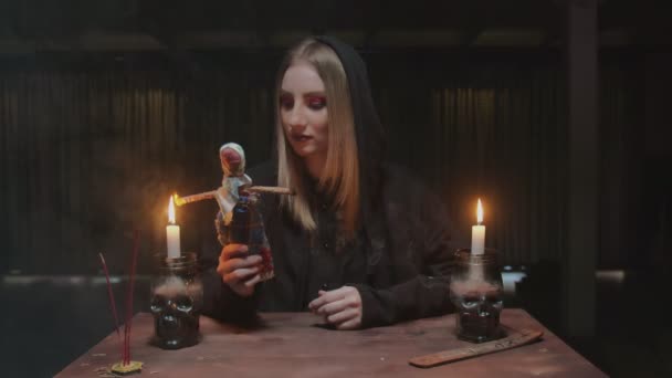 Jeune sorcière diseuse de bonne aventure met le feu aux mains de la poupée vaudou dans un terrible rituel magique - Séquence, vidéo