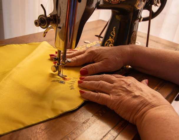 Naaister naaien met oude naaimachine - Foto, afbeelding