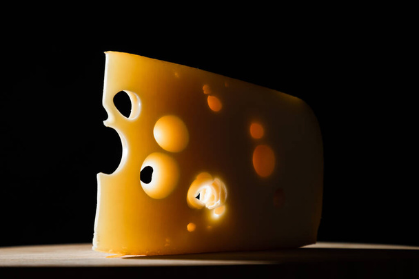 Yellow cow's milk Swiss cheese emmenthal with holes on wooden board - Foto, Bild