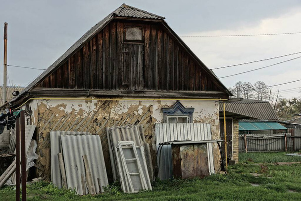 фасад старого сільського будинку з коричневим дерев'яним горищем зовні в зеленій траві
 - Фото, зображення