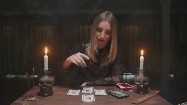 Mladá čarodějnice věštkyně používá tarotové karty, kostky a telefon ke čtení budoucnosti - Záběry, video