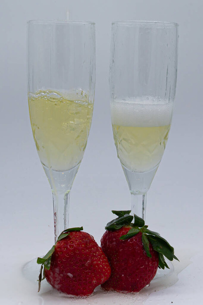 Glasses of champagne with red strawberries and green stem on white background. Valentine's Day. Fresh fruit. Healthy food - Zdjęcie, obraz