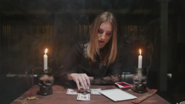 Fiatal boszorkány női jövendőmondó használ tarot kártya, kocka és tabletta olvasni a jövőben - Felvétel, videó