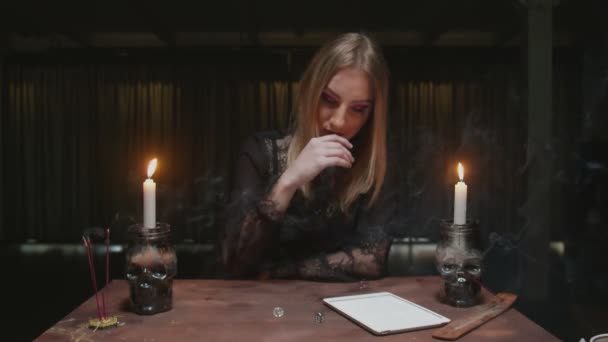 Jonge heks vrouwelijke waarzegster gebruikt dobbelstenen en tablet om de toekomst te lezen - Video