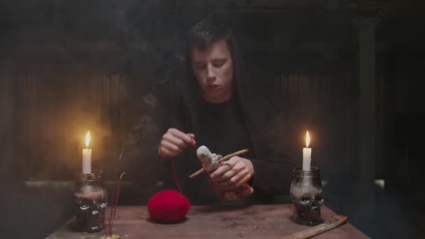 Koncentrált titokzatos varázsló férfi jövendőmondó használ voodoo baba és piros kötél szörnyű mágikus rituálé - Felvétel, videó