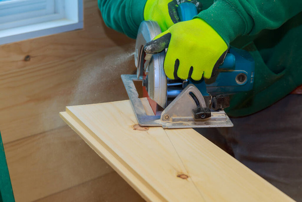 Rakentaminen yksityiskohdat mies työntekijä puuseppä käyttäen pyörösaha leikkaamiseen puulevyjen sähkötyökaluja - Valokuva, kuva