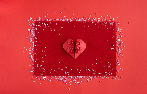 cuore di carta rossa sdraiato su sfondo di carta, vista dall'alto, giorno di San Valentino - Foto, immagini