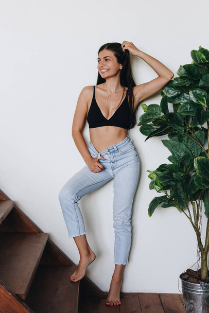 Beautiful young woman wearing jeans at home - Φωτογραφία, εικόνα