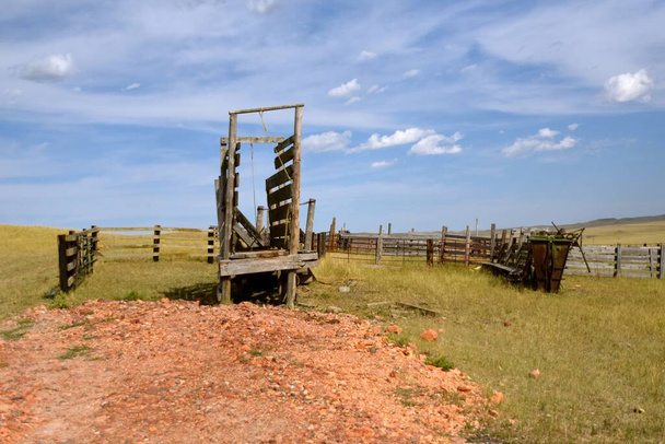 Парашют и забор, окружающие старый деревянный загон, остаются на фоне западных равнин. - Фото, изображение