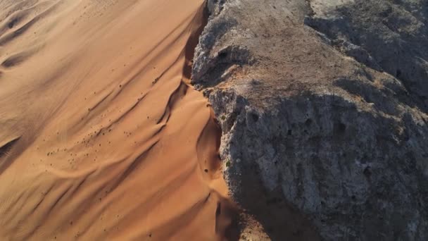 Γραφικό Ορυκτό Βράχο στην έρημο Σάρζα των Ηνωμένων Αραβικών Εμιράτων εναέρια πλάνα. Άμμος συναντά το βραχώδες βουνό στην έρημο των ΗΑΕ - Πλάνα, βίντεο