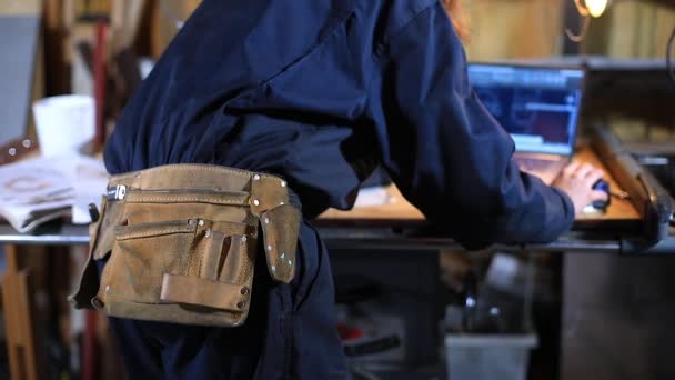 Artesana femenina con cinturón usando laptop - Metraje, vídeo