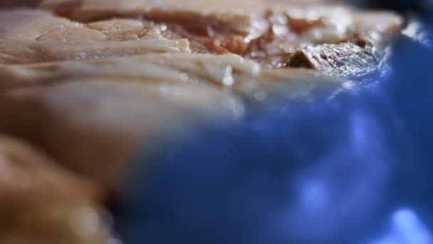 Makró kilátás egy dobozra tele fagyasztott csirkelábakkal. Jéggel borított, fagyasztott nyers csirkehús. 4k videó - Felvétel, videó