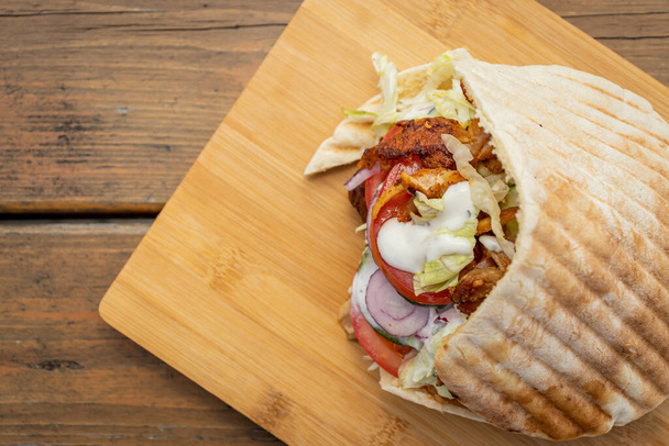 Doner Kebab op een lokale straat eetkraam op houten snijplank - Foto, afbeelding