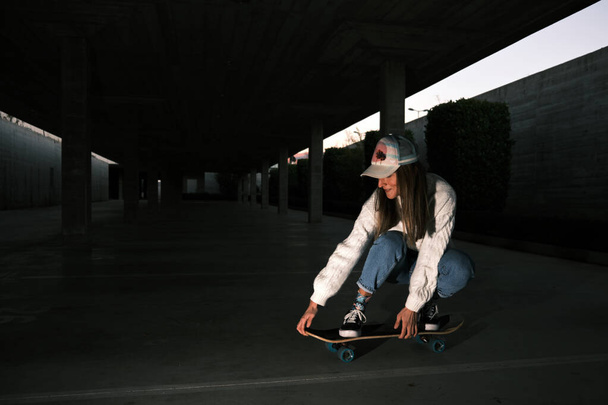 mujer joven patinando en un estacionamiento - Foto, imagen