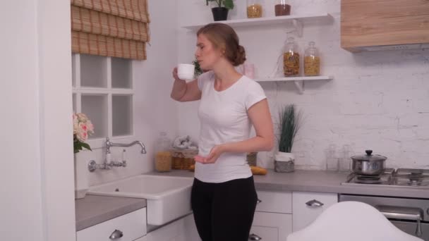 young woman taking pills in the kitchen - Materiał filmowy, wideo
