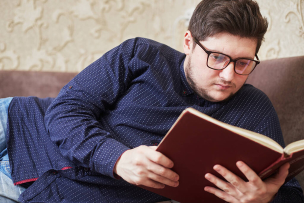 caucasian man with glasses reading a book, copy space - Photo, image
