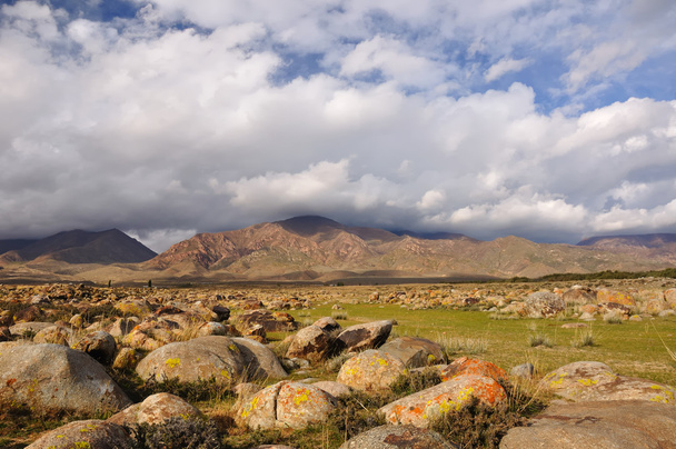 Pedregulhos e nuvens nas montanhas do Quirguistão
 - Foto, Imagem