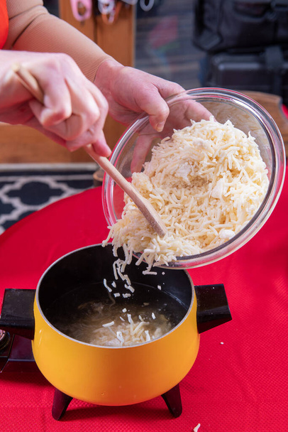 Preparación del queso suizo que se vierte en aceite para fondue para mojar el pan - Foto, Imagen