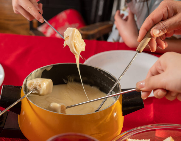 Pain trempé dans du fromage suisse pour le dîner à la fondue - Photo, image