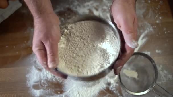 A professional pastry chef sifts flour through a sieve. View from above. Concept: production of sweets, pies, dough, pizza, delicacy, pure product, baking, working in restaurants, baking - Footage, Video