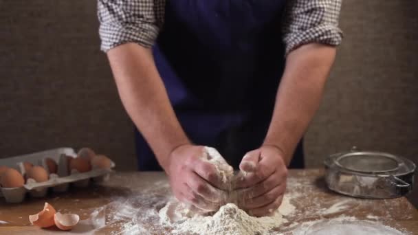 gros plan mains masculines d'un cuisinier, commence à pétrir la pâte à partir d'ingrédients. Concept : production de bonbons, tartes, pâte, délicatesse, produit pur, cuisson, travail dans les restaurants, - Séquence, vidéo