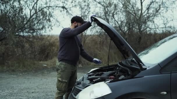 Kaukasier senkt die Motorhaube des Autos. Das Konzept einer Autopanne außerhalb der Stadt. - Filmmaterial, Video