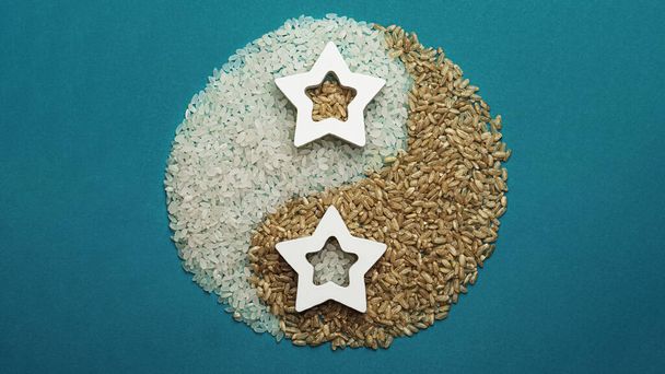 Light and dark rice. Yin and Yang symbol. On a turquoise background. - 写真・画像