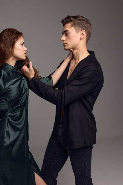 Um homem com uma jaqueta escura toca o cabelo em uma cabeça de mulher e um conflito de desconfiança - Foto, Imagem