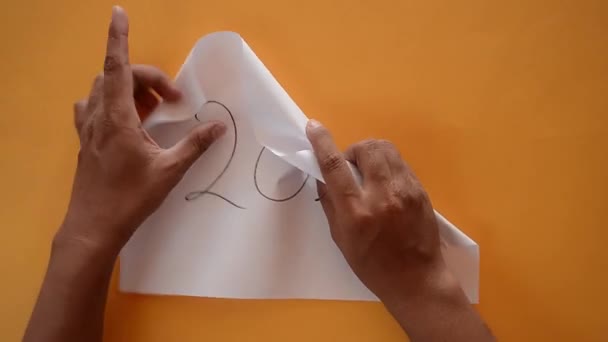 Mano de hombre arrugando una hoja de papel que escribió 2020. concepto de resolución de año nuevo - Imágenes, Vídeo