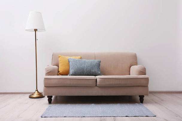 Simple room interior with comfortable beige sofa - Zdjęcie, obraz